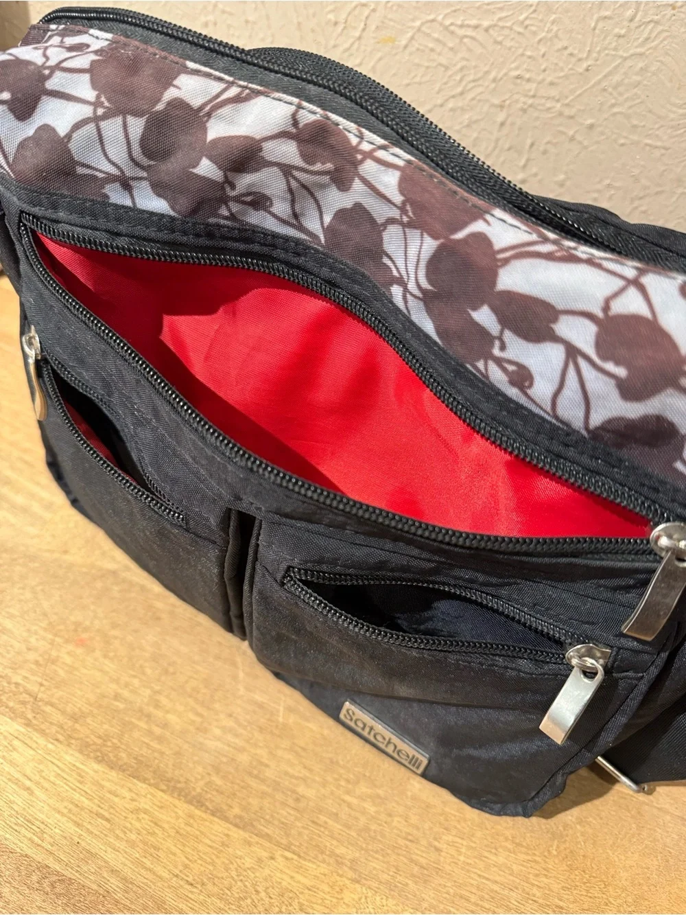 Satchelli Black Crossbody Bag with Floral Accent and Red Lining